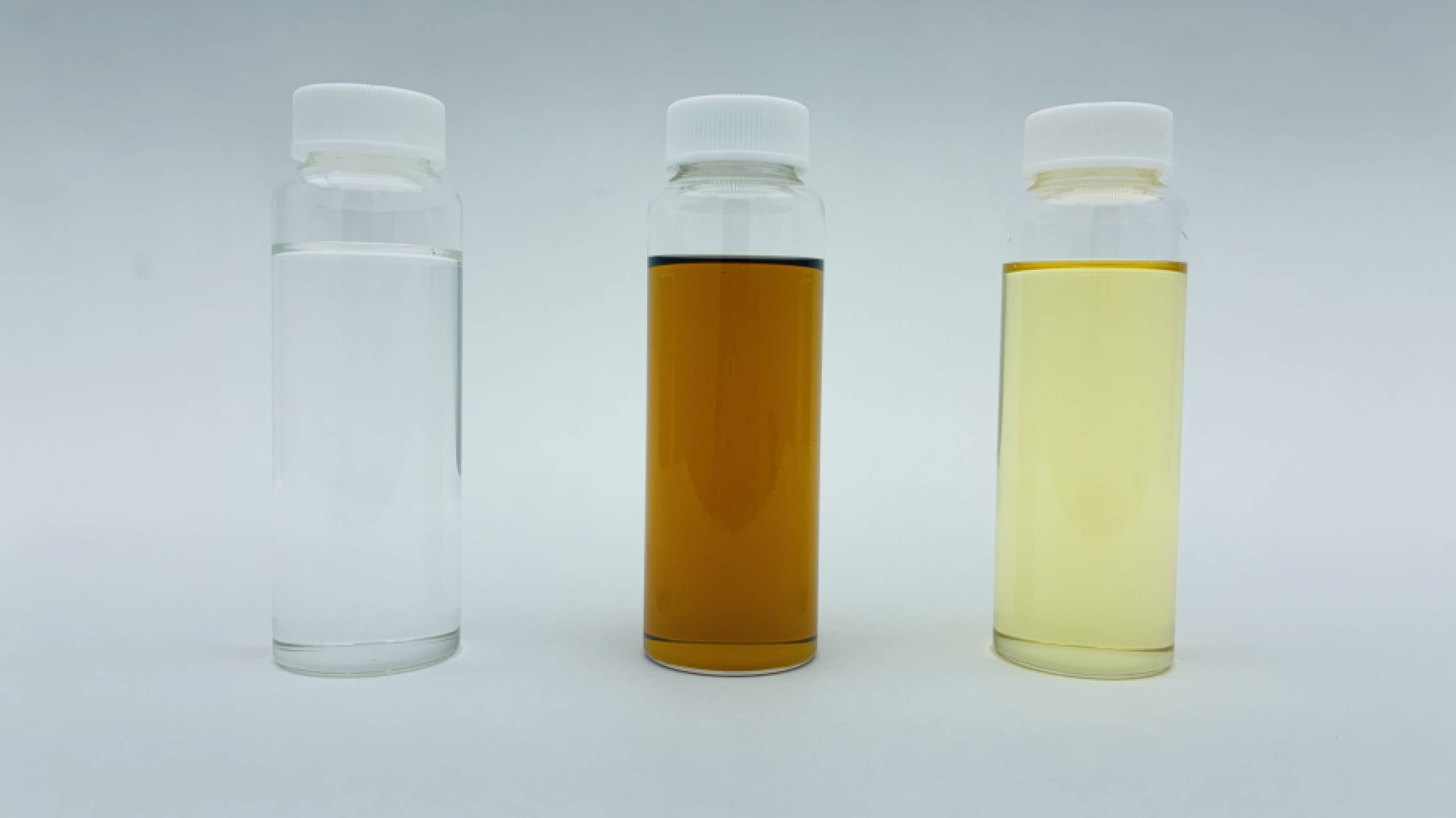 From left in the photo are a bio-derived base oil developed by ENEOS, and engine and transmission oils made from it